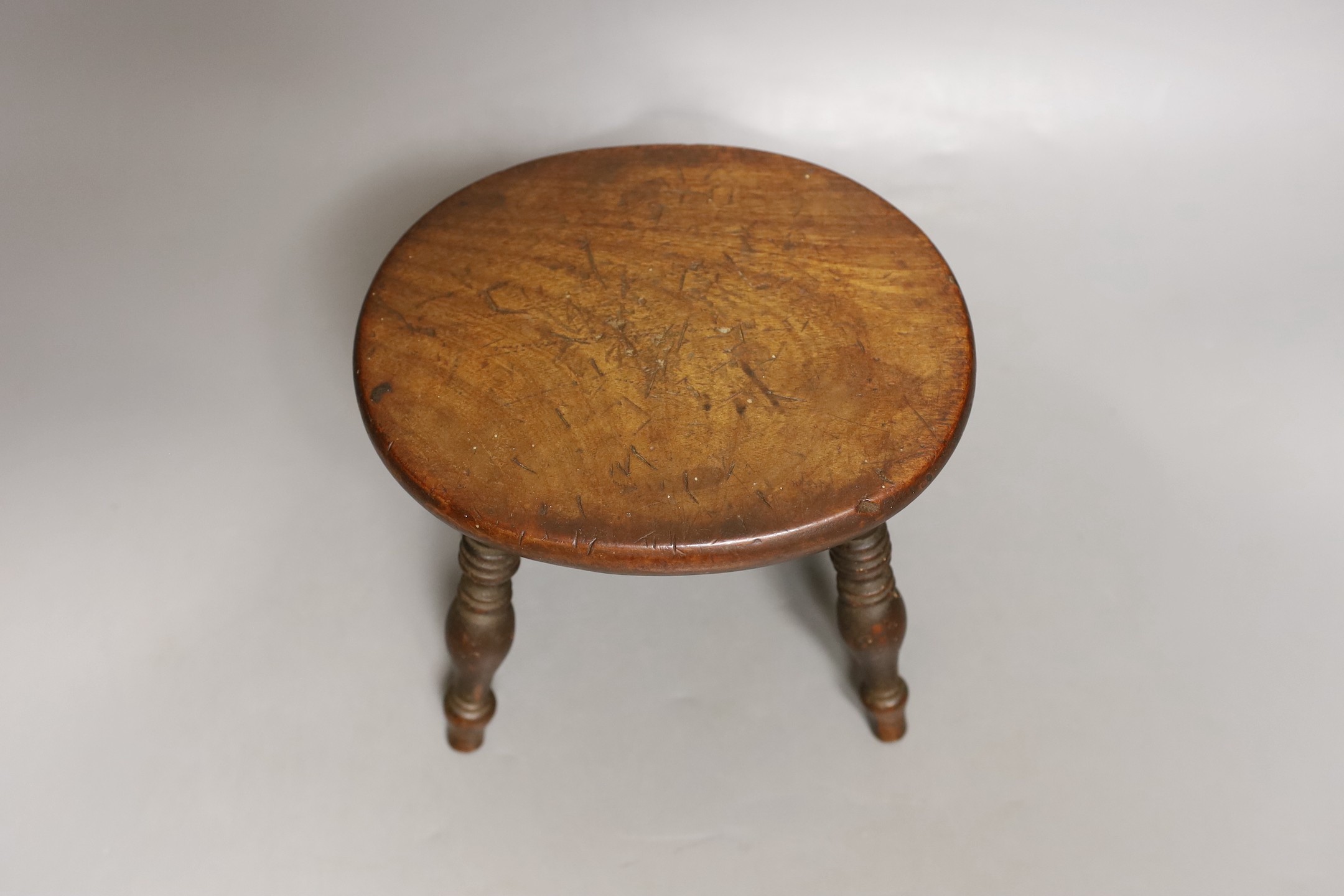 A 19th century walnut miniature stool, 12.5 cms high.